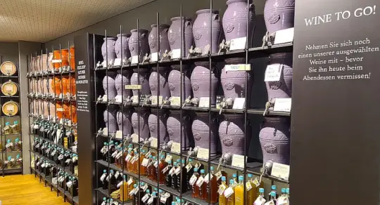 Eine Wand mit mehreren farbigen Öl- und Essigfässern und Flaschen.