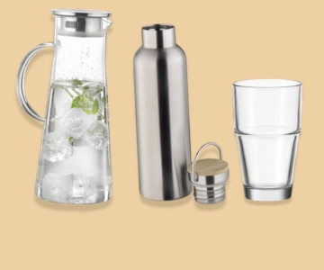 Karaffe, Flasche und Glas vor braunem Hintergrund.