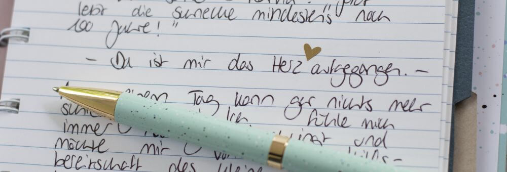 Nahaufnahme eins Notizbuchs von Filofax. Zu sehen ist ein Tagebucheintrag und der Satz "Da ist mit das Herz aufgegangen". Darunter liegt ein Kugelschreiber.