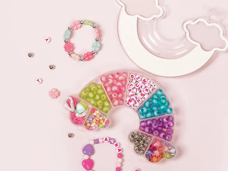 Auf einem rosa Tisch liegt ein Schmuckset in Regenbogenform von KNORR prandell) 