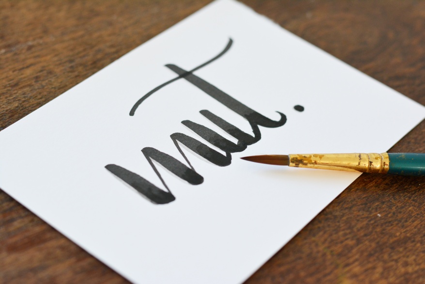 Das Wort "Mut" wurde mit einem Pinsel auf eine Karte gelettert.