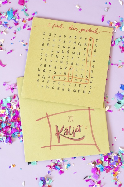 DIY-Rätselkarte mit Umschlag für Katja auf rosa Untergrund mit Konfetti