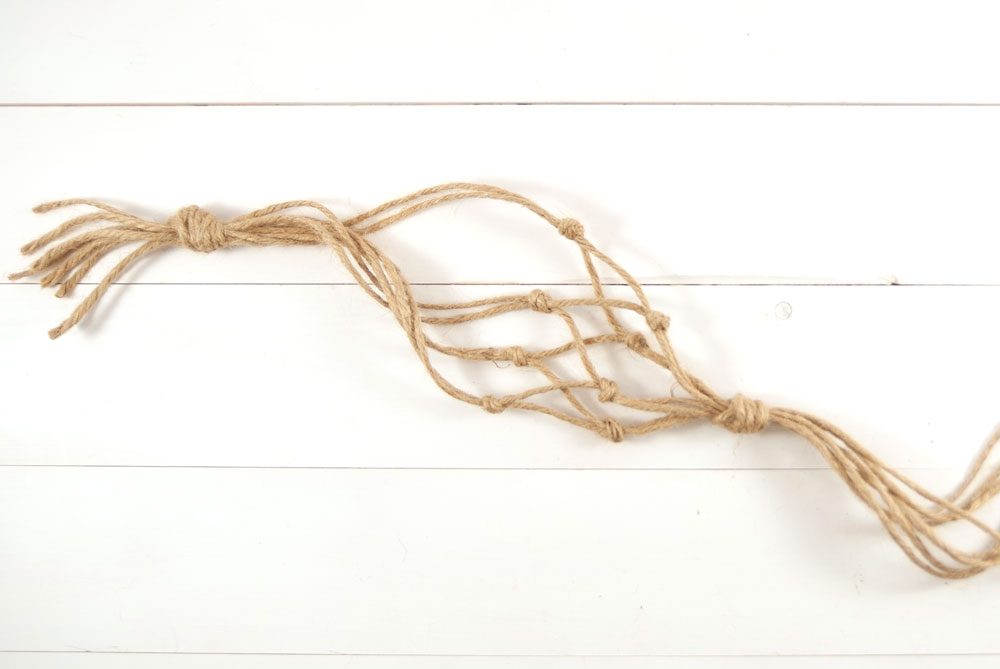Mehrere zusammengeknotete Kordelenden liegen auf einem Tisch.