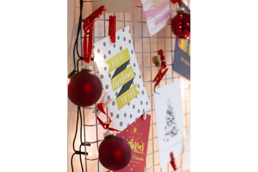 Weihnachtskarte mit Punkten und Weihnachtskugeln an Gitter befestigt