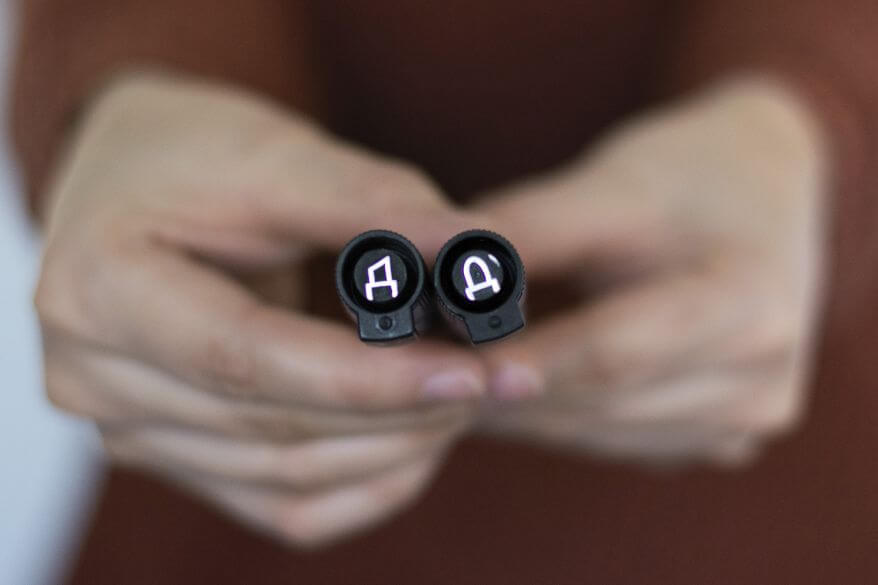 Detailaufnahme von zwei Händen, die zwei Kappen der Whiteboardmarker Lumocolor von Staedtler präsentieren: Einmal mit Keilspitze, einmal mit Rundspitze.