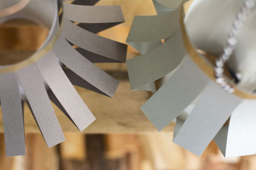 Nahaufnahme von zwei selbstgebastelten DIY-Papierlaternen mit Papierstreifen von unterschiedlicher Breite.