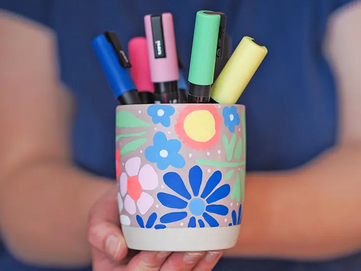 Jemand hält einen Becher mit Markern von POSCA in den Händen. Foto: Johanna Rundel