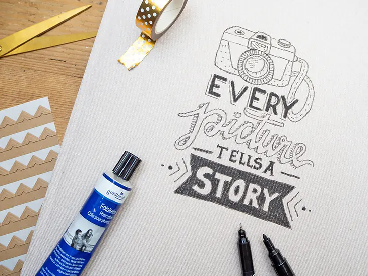 Nahaufnahme eines Handletterings „Every picture tells a story“ auf einem hellbeigen Fotoalbum von Goldbuch mit Leineneinband. Foto: Johanna Rundel