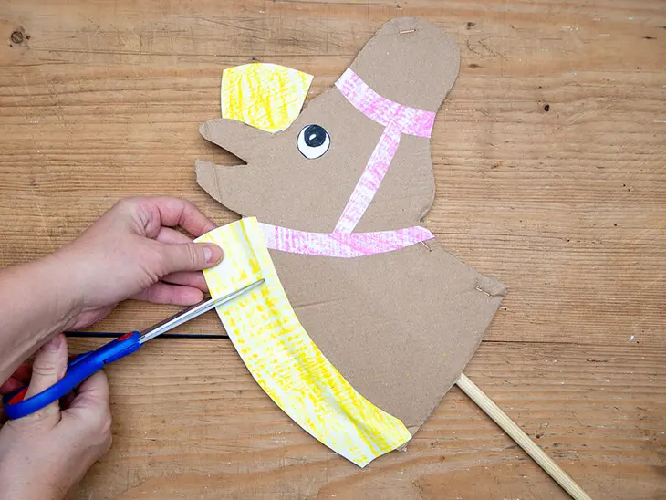 Jemand schneidet mit einer Schere von STAEDTLER die Mähne eines DIY-Steckenpferds aus Pappe in Fransen. Foto: Johanna Rundel)