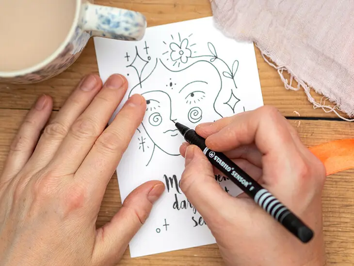 Jemand zeichnet mit einem STABILO-Stift ein Lettering auf eine Affirmationskarte. Foto: Johanna Rundel