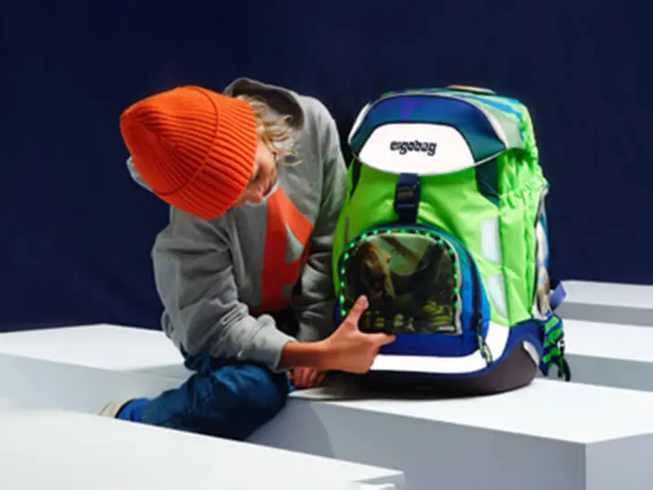 Ein Kind antiviert die LED-Leuchten an seinem ergobag-Schulranzen.