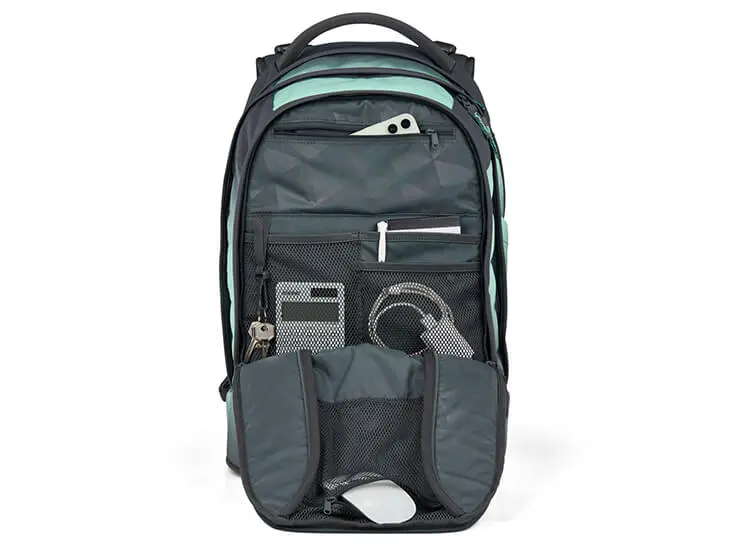 Grauer Schulrucksack von satch mit geöffneter Fronttasche mit Kleinteilen darin.