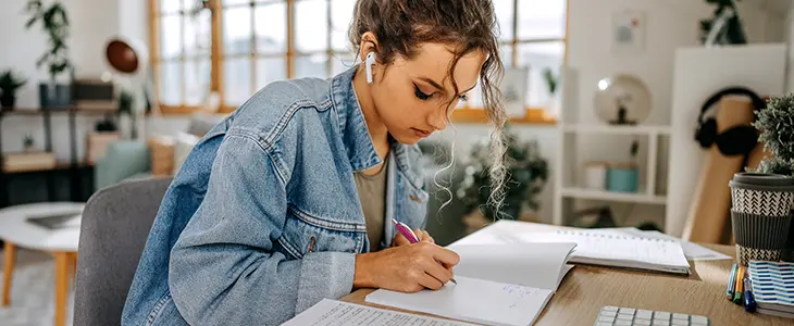 Eine Frau schreibt an einem Schreibtisch auf einem Block