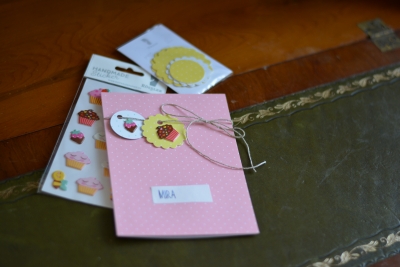 Auf einer rosa Karte sind Sticker aufgeklebt. Daneben liegt die Verpackung der Marke Rössler mit weiteren Motiven.