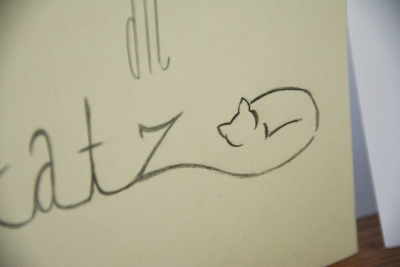 Nahaufnahme eines Doodles einer Katze, welche an das Wort "Katz" anschließt. 