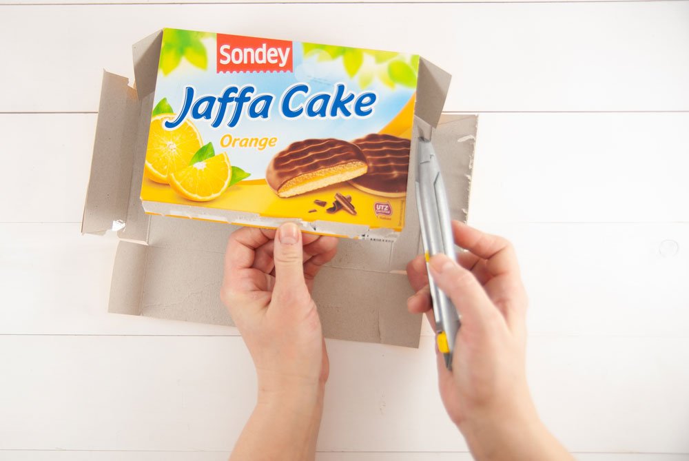 Jaffa-Cake-Verpackung wird für DIY-Projekt mit Cutter-Messer zerschnitten