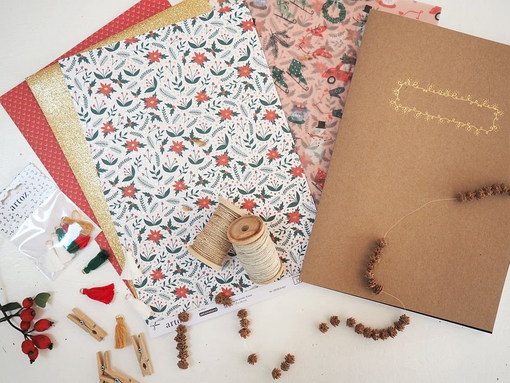 Weihnachtliches Bastelmaterial mit gemustertem Papier, Garn und Deko-Elementen.