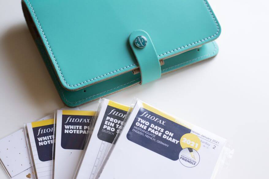 Auf einem Schreibtisch liegt ein Personal Timer von Filofax und verschiedene Einlagen.