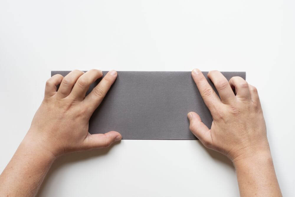 Laterne basteln aus Papier, Bastelanleitung Schritt 1: Falten Sie einen DIN a4-Bogen Tonpapier der Länge nach.