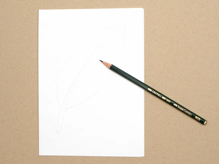 Auf ein Blatt wurde mit Bleistift der Umriss einer Vogelfeder gemalt. Ein Bleistift von Faber-Castell liegt darauf. Foto: Johanna Rundel