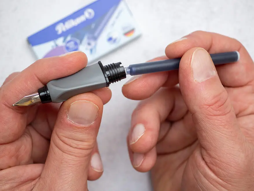 Jemand steckt eine Großraum-Tintenpatronen in einen Twist-Füller von Pelikan. Foto: Johanna Rundel