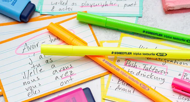 Auf einem grauen Untergrund liegen mit Stiften von STAEDTLER selbst gestaltete Lernkarten zur Vorbereitung auf Klassenarbeiten für verschiedene Fächer. Foto: Johanna Rundel