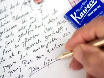 Jemand schreibt mit einem goldenen Füller von Kaweco, "Dein Opa" unter einen Brief ans Enkelkind. Foto: Johanna Rundel