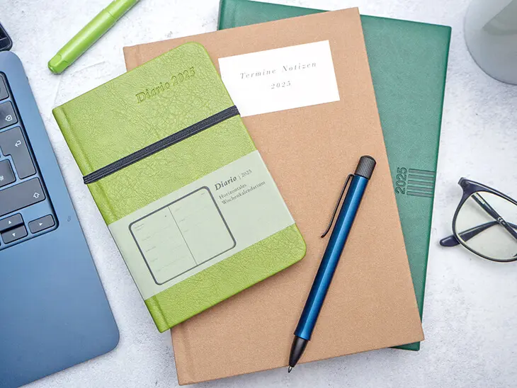 Planer von Athesia in verschiedenen Formaten und Farben liegen auf einem Büroschreibtisch. Foto: Johanna Rundel