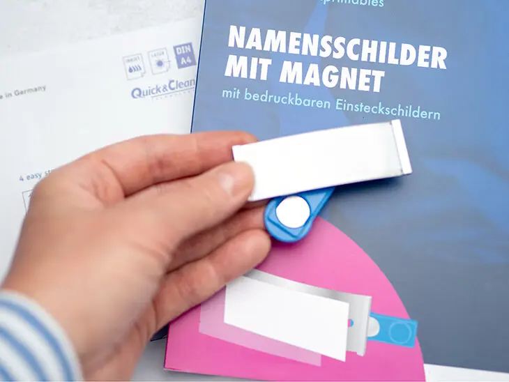 Jemand hält ein magnetisches Namensschild von Avery Zweckform über die Verpackung eben dieses. Foto: Johanna Rundel