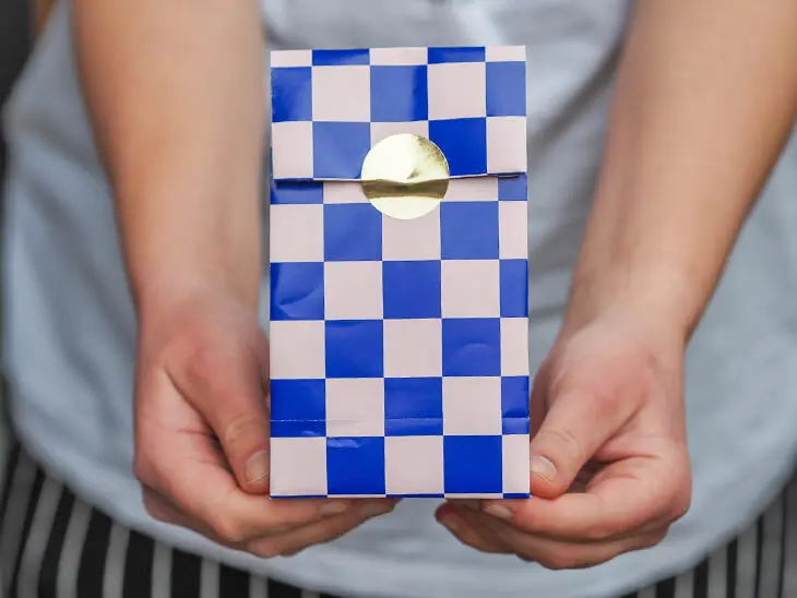 Jemand hält eine selbstgebastelte Geschenktüte aus Geschenkpapier von STEWO in die Kamera. Foto: Johanna Rundel