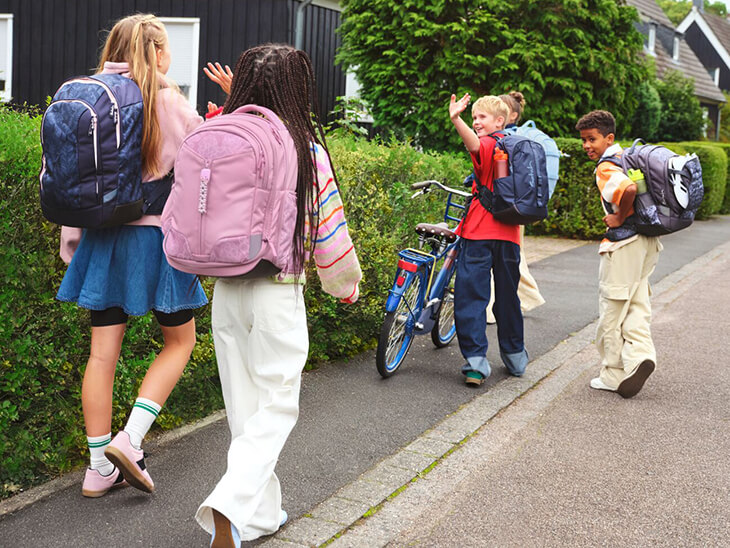 Eine Gruppe Teenager mit Schulrucksäcken von satch auf dem Schulweg.