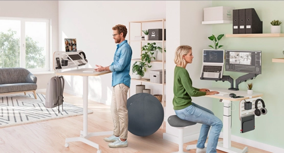 Zwei Personen sitzen an Ihren ergonomischen Schreibtischen.