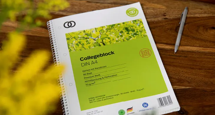 Auf holzfarbenem Grund liegt ein Collegeblock der Marke oeco von Soennecken.