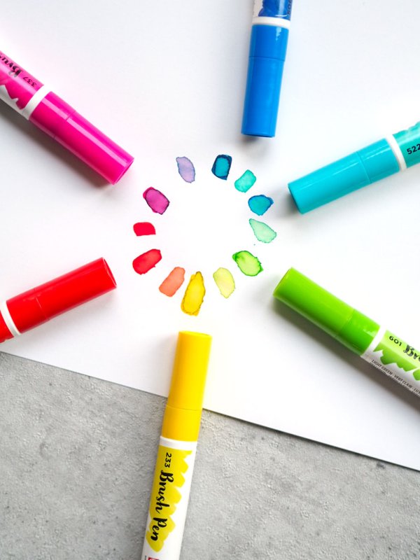 Farbige Brush Pens von Ecoline auf Papier mit einem gemalten Farbkreis.