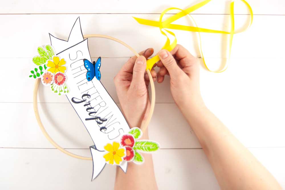 Gelbes Band wird am Dekoreif zur Aufhängung befestigt