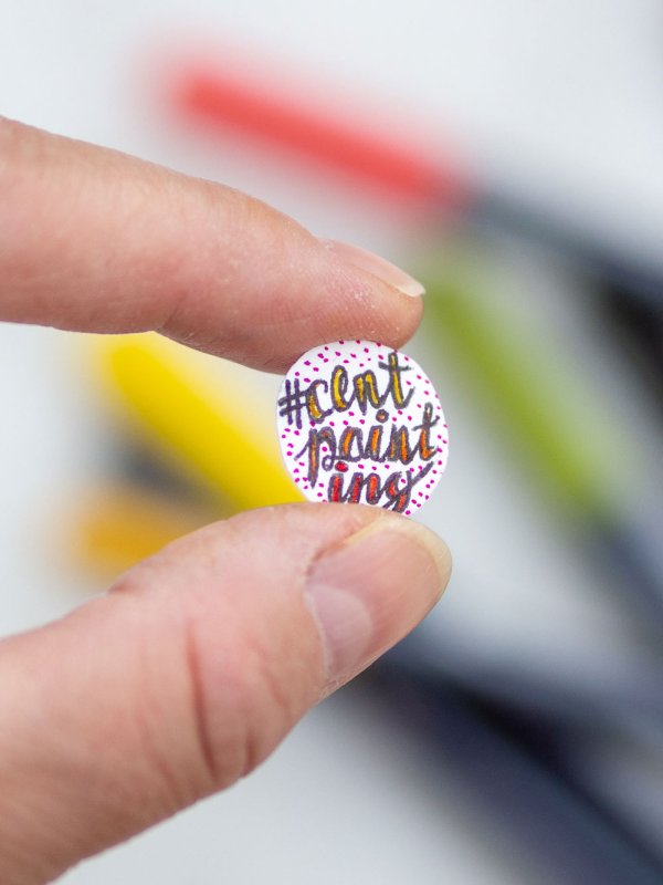 #centpainting Schriftzug auf Mini-Zeichnung zwischen Fingern