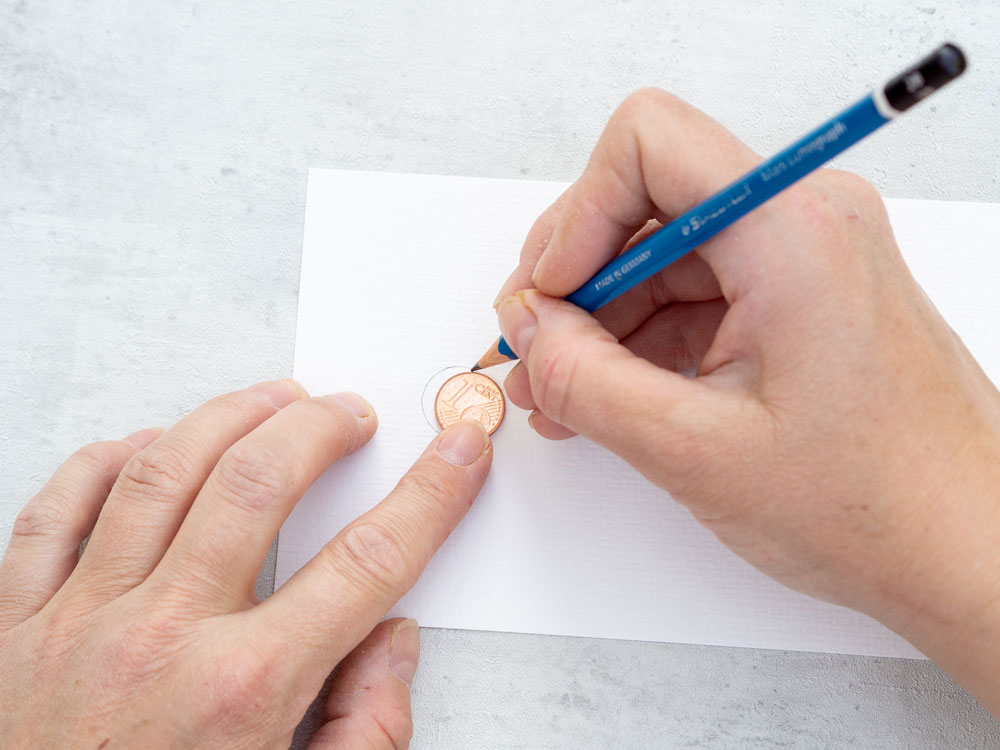 1-Cent-Stück wird auf Papier nachgezeichnet mit Bleistift