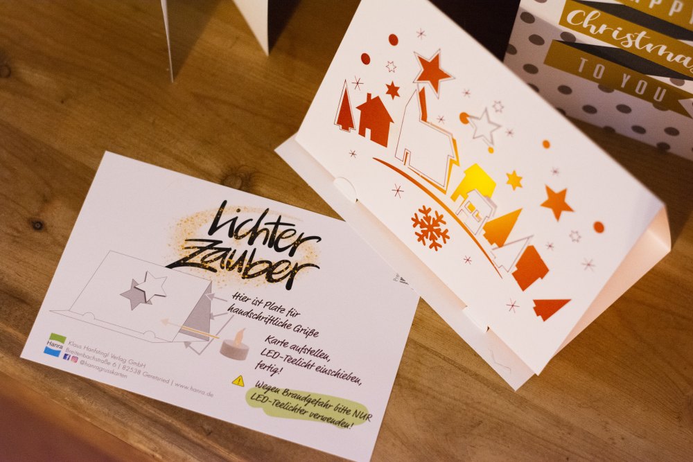 Papierkarte mit ausgestanztem Dorfmotiv, daneben die Anleitung zum Aufstellen.