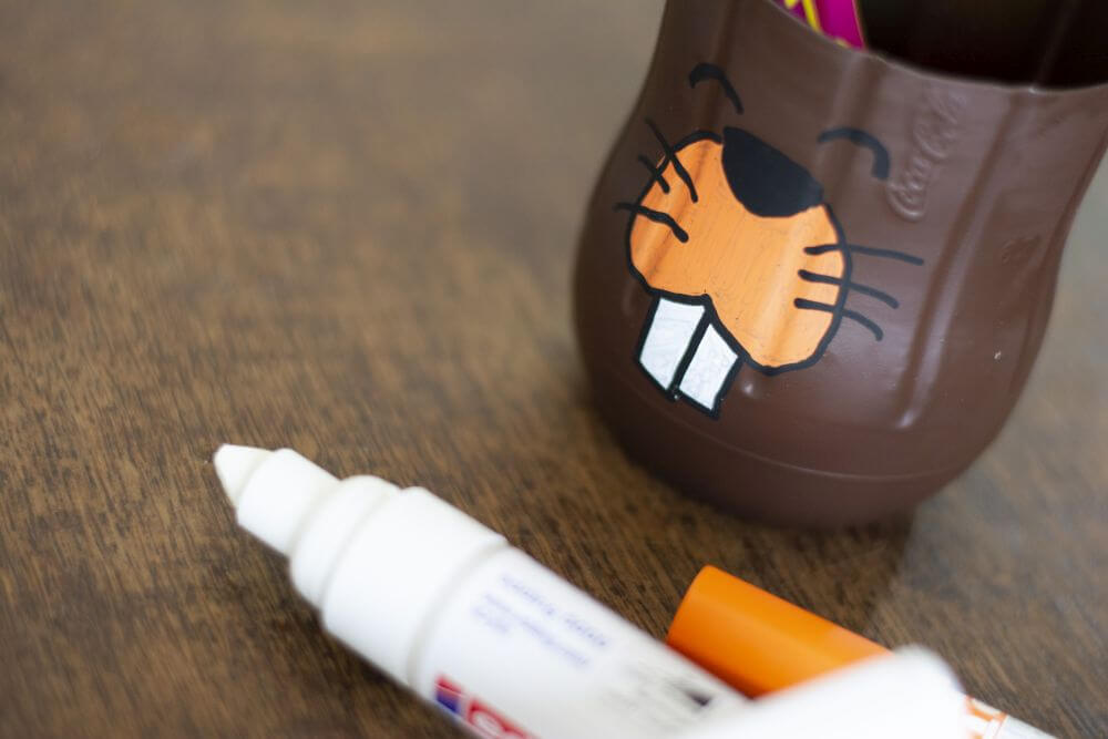 Ein Zahnputzbecher aus einer PET-Flasche wurde mit Hilfe eines Lackmarkers bemalt. Er sieht aus wie ein Biber.