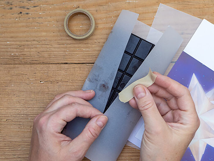 Jemand packt eine selbstgemachte vegane Schokoladentafel in weißes Transparentpapier ein. Foto: Johanna Rundel