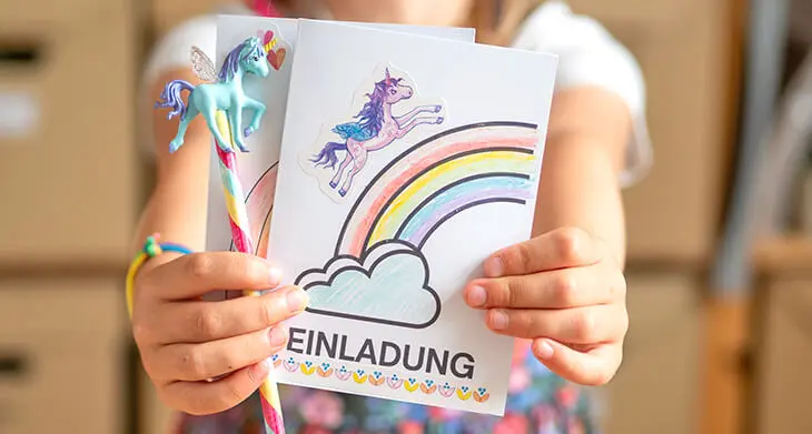 Ein Kind hält eine, mit Produkten von Coppenrath selbstgestaltete, Einhorn-Geburtstags-Einladung in die Kamera. Foto: Johanna Rundel)