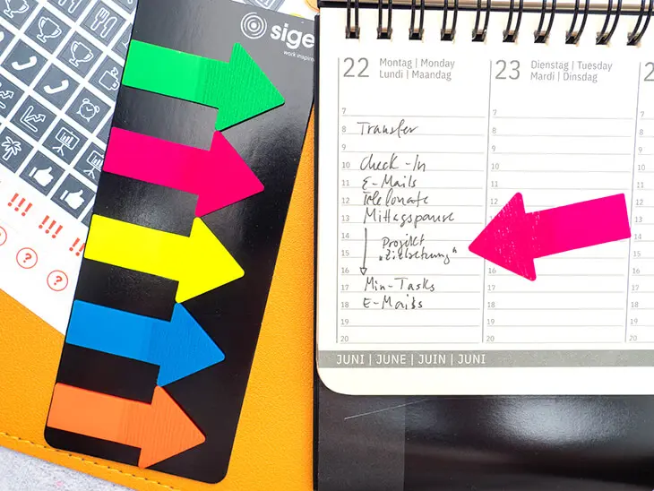 Ein neonpinker Pfeil zeigt auf einen Zeitblock in einem Wochenplaner von Sigel. Foto: Johanna Rundel