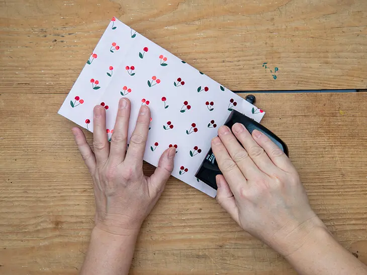 Jemand locht eine Geschenktüte aus Geschenkpapier von STEWO. Foto: Johanna Rundel)