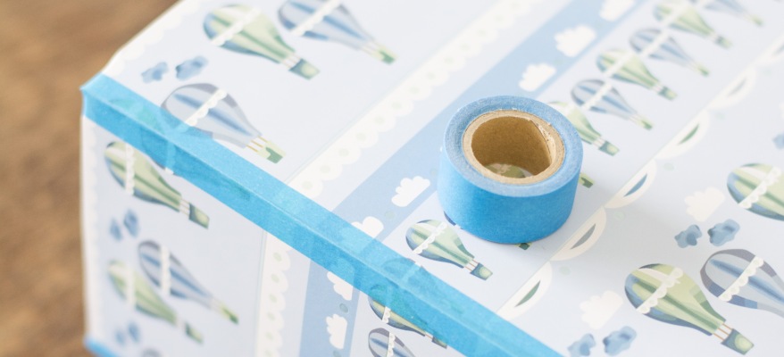 Ein blaues Wahitape liegt auf einem mit selbstklebender Folie gestalteten Müslibox.