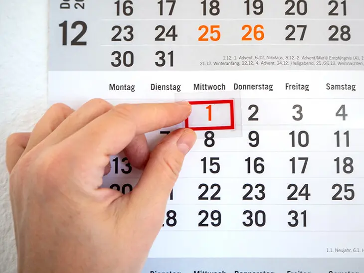 Jemand bewegt den Schieber an einem Wandkalender von Athesia eine Zahl weiter nach rechts. Foto: Johanna Rundel