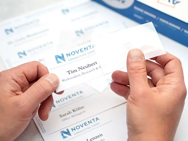 Jemand steckt ein vorgedrucktes Namensetikett von Avery Zweckform in ein passendes Einsteckschild aus Plastik. Foto: Johanna Rundel