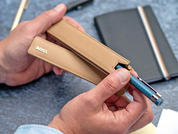 Jemand zieht einen Füller von HUGO BOSS aus einem Etui. Foto: Johanna Rundel
