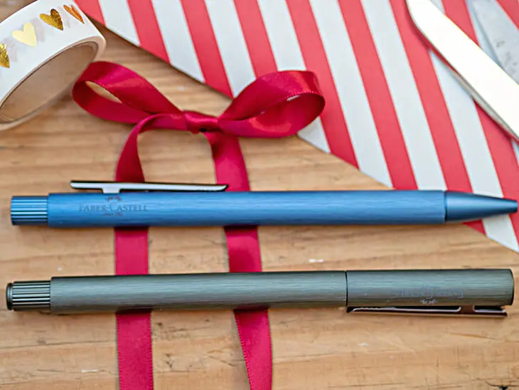 Zwei Schreibgeräte von Faber-Castell liegen auf einer roten Satinschleife. Foto: Johanna Rundel