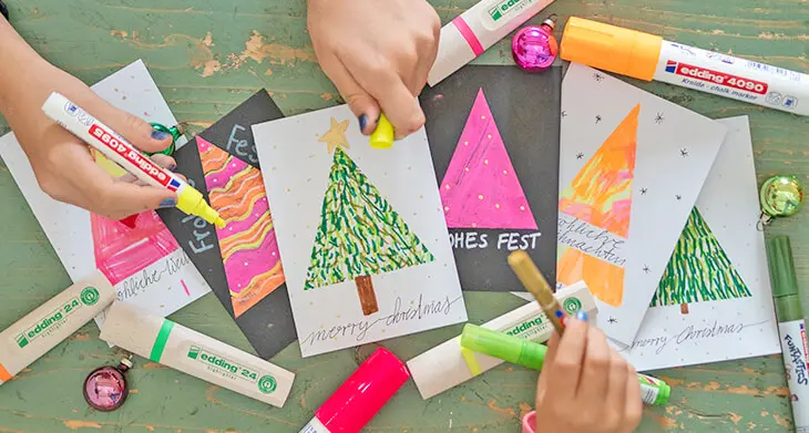 Zwei Kinder basteln Weihnachtskarten mit Stiften von edding. Foto: Johanna Rundel