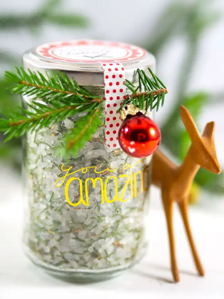 Nahaufnahme eines Marmeladenglases, befüllt mit selbstgemachten Badesalz und weihnachtlich dekoriert